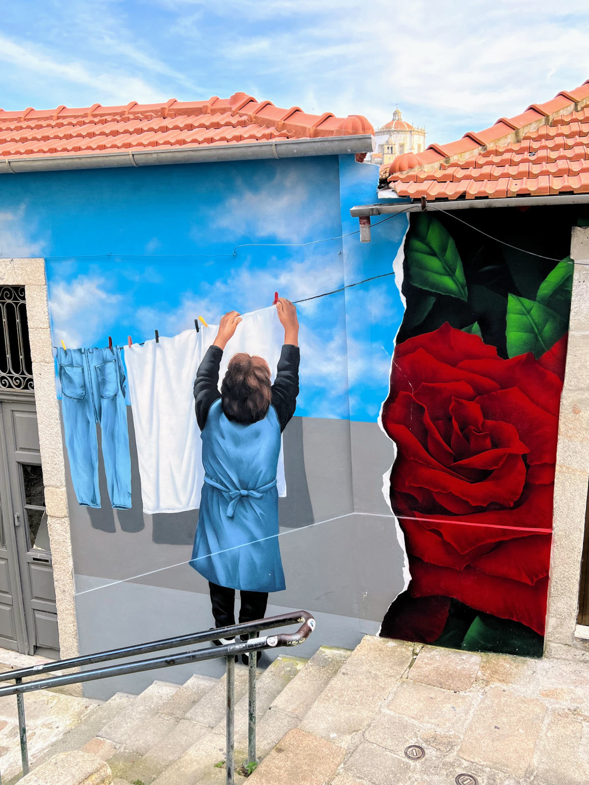 Large wall mural showing a woman hanging laundry.