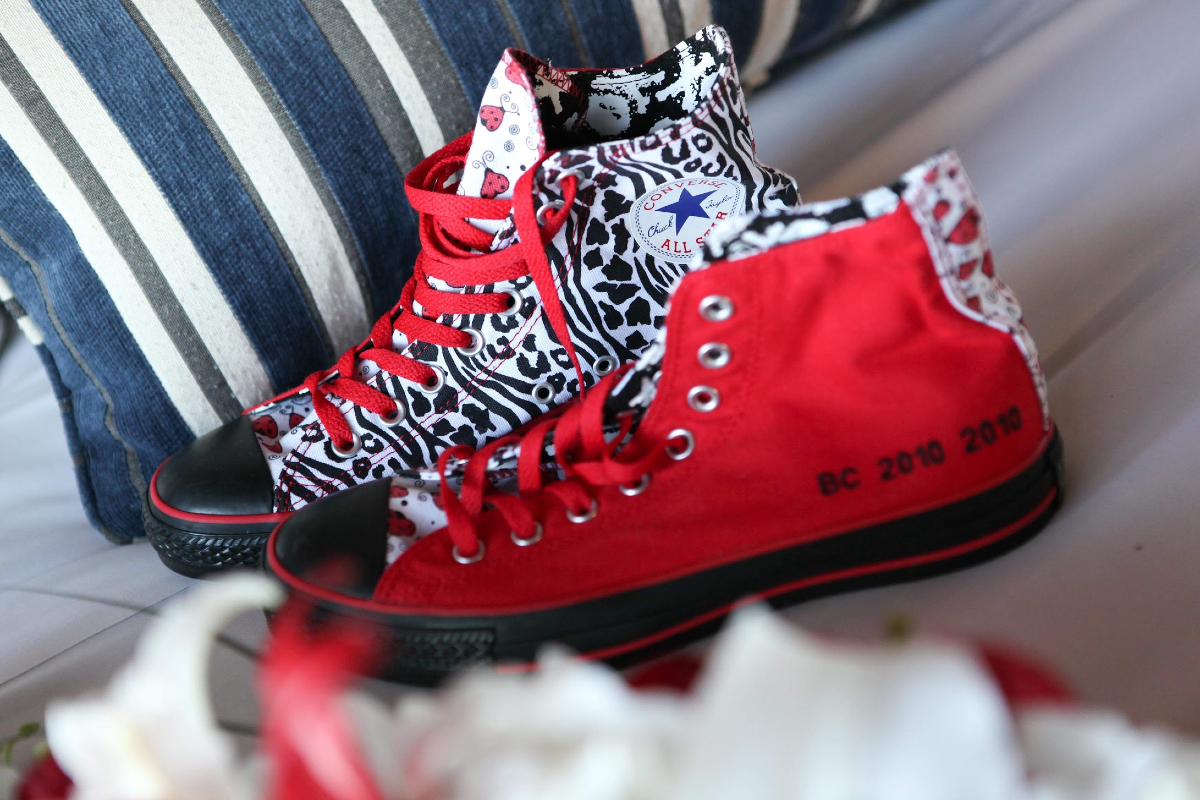 A pair of red, white and black Converse-brand hi-top sneakers.