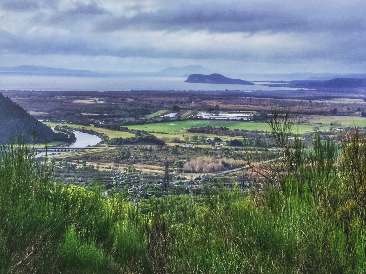 View over green rural land including bushes, river, and out to the Bay with islands in the Bay.