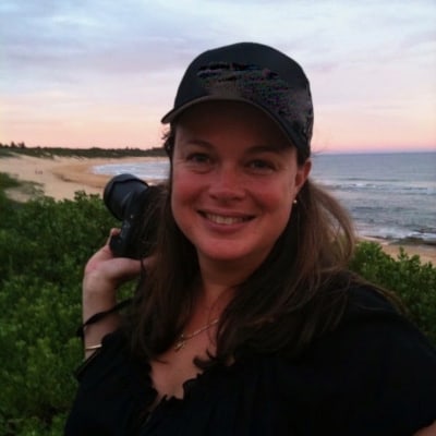 Belinda holding a camera at the beach.